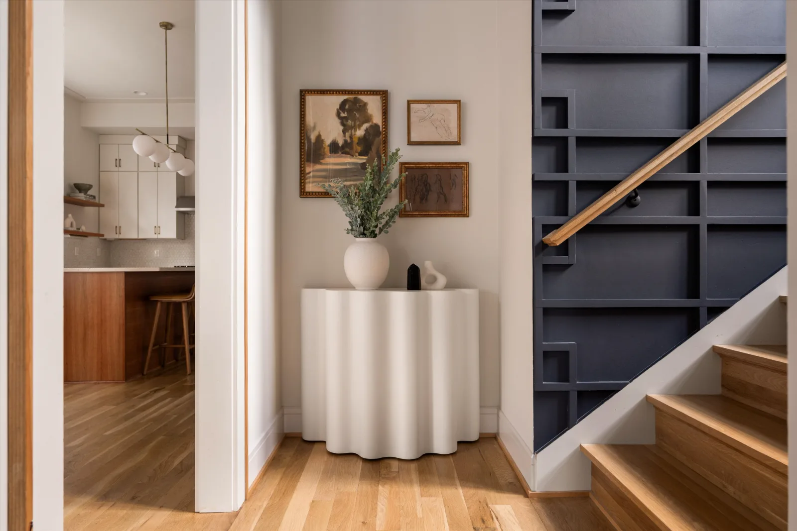 The stair hall, navy fretwork screen and art wall