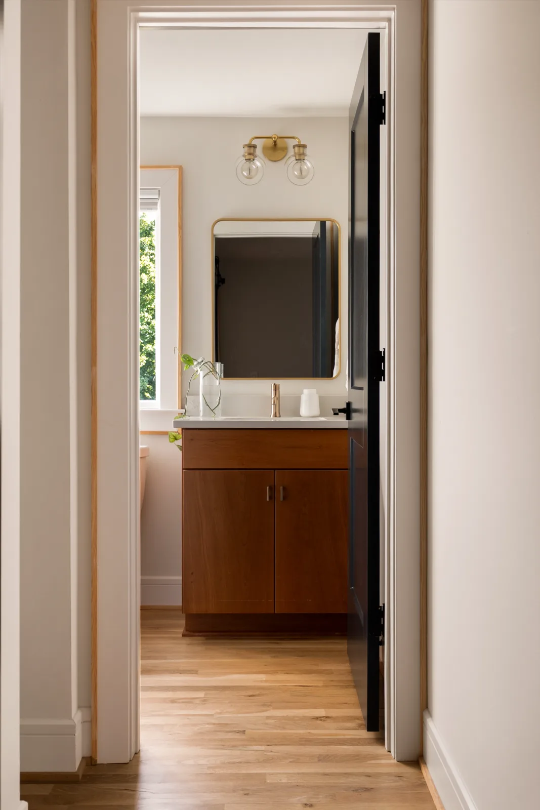 Through the doorway from the bonus room: the bath around the corner, cherry vanity, quartz top and brass fittings