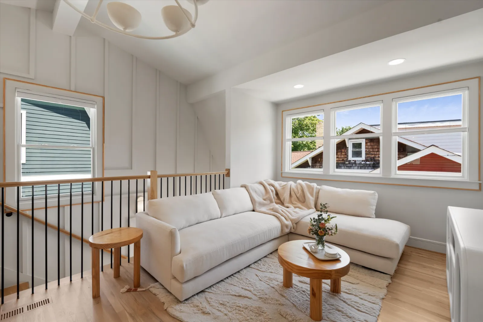 The living room with the stair rail and panelled wall
