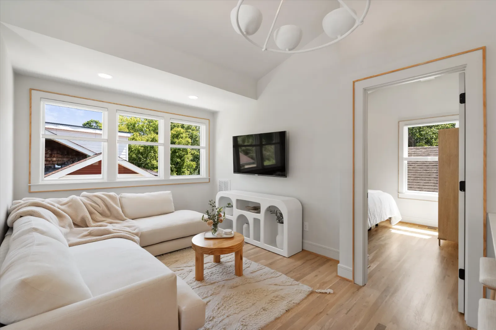 The guest suite living room under a vaulted ceiling, open to the bedroom beyond