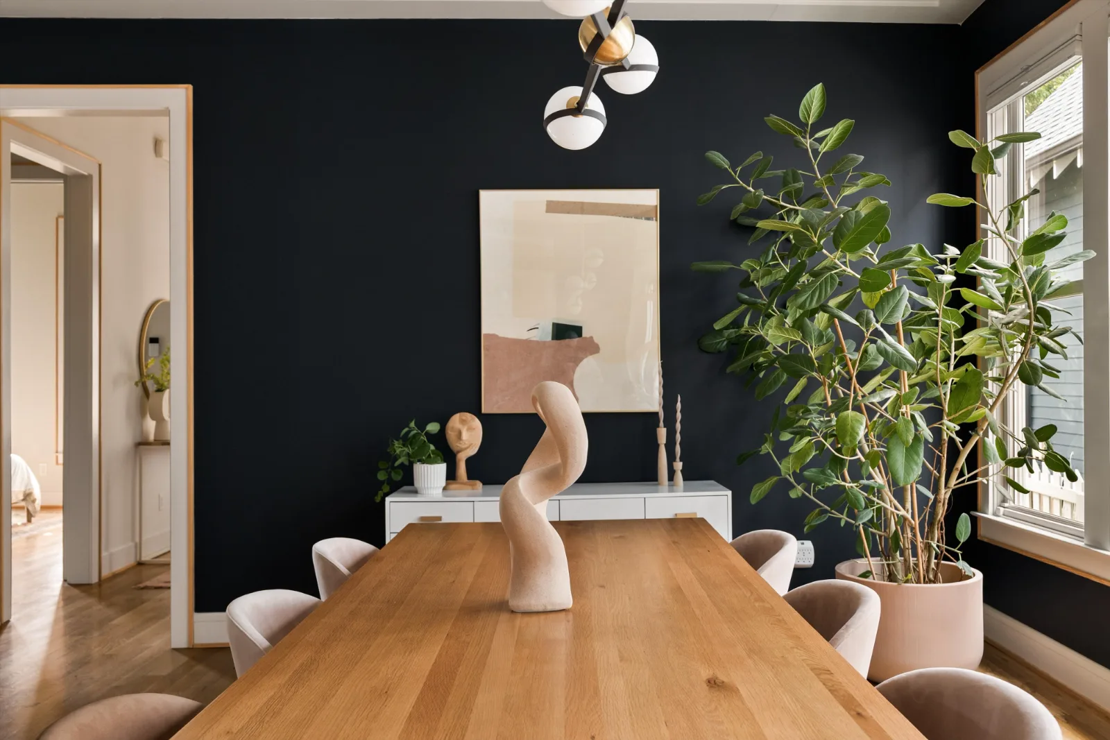 The far end of the dining room: sideboard, artwork and the fiddle-leaf fig by the window